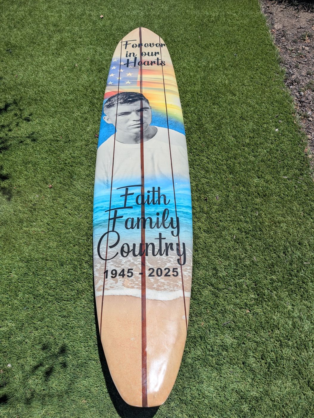 The restored longboard finished with memorial artwork on the deck