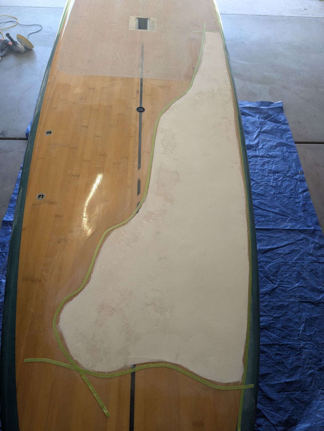 Bamboo paddleboard with the delaminated deck skin cut away to bare foam
