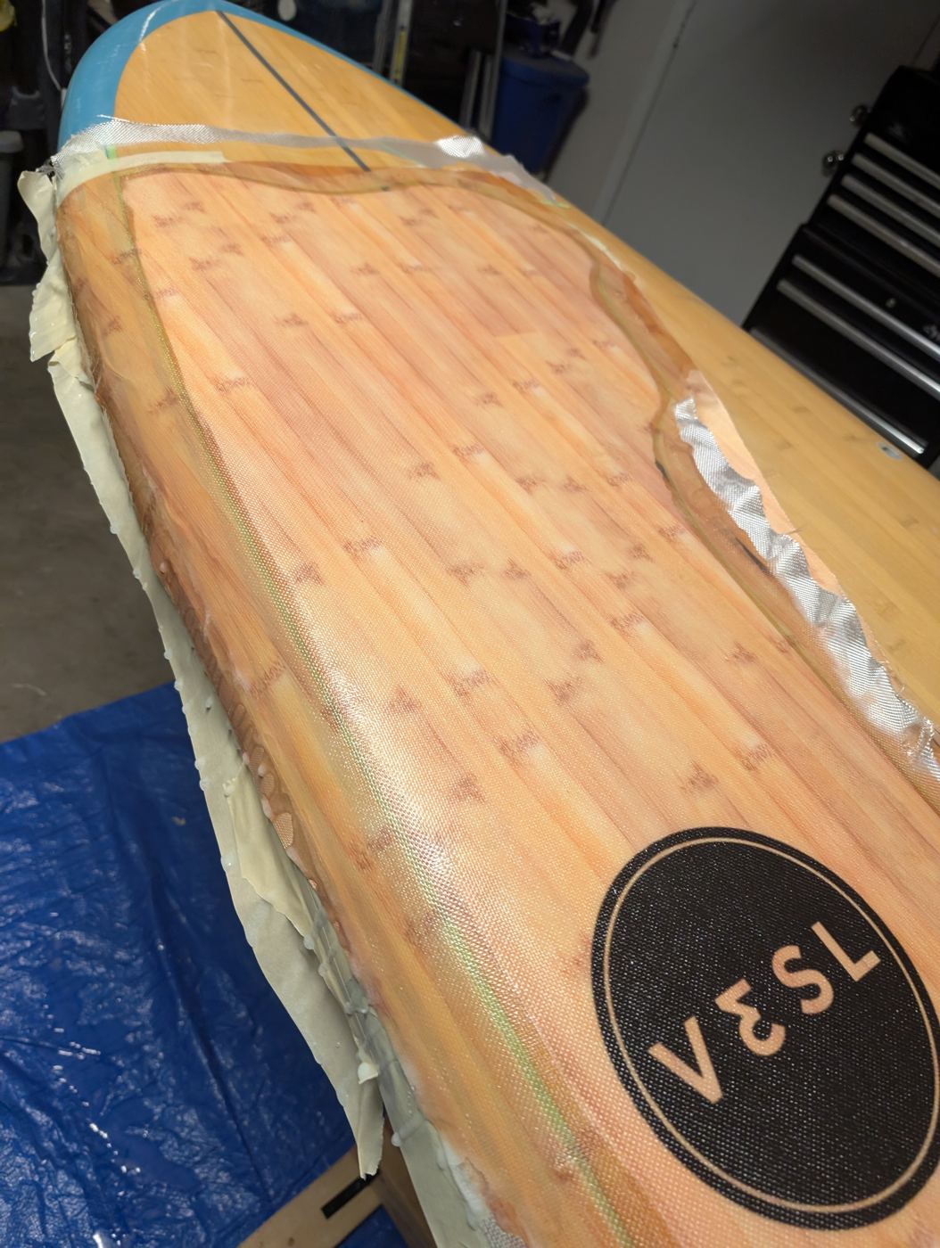 Fresh lamination curing on the nose of a bamboo paddleboard